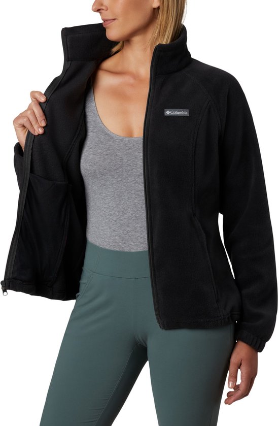 Vrouw met openstaande zwarte Columbia fleece trui. Binnenkant met een zak te zien.