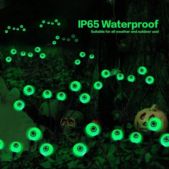 Groene ooglampjes in het donker, met pompoen, schedel en verlichte takken.