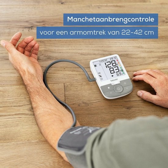 Close-up van een man die een bloeddrukmeter gebruikt. "Manchetaanbrengcontrole voor een armomtrek van 22-42 cm".