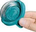Hand houdt een turquoise deksel vast, met glazen bodem erop.