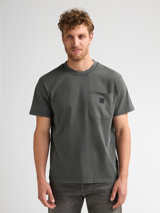 Man in donkergroen T-shirt met borstzakje.