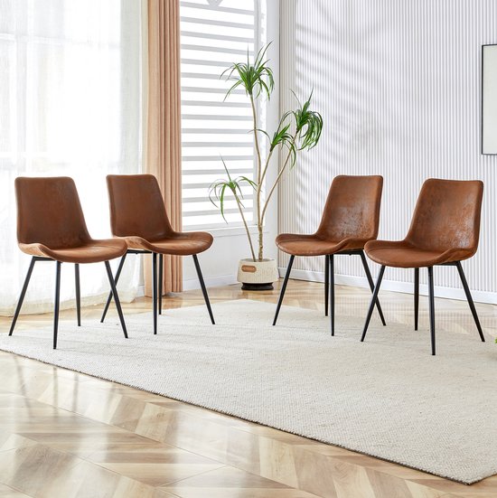 Quatre chaises de salle à manger marron avec des pieds noirs sont placées sur un tapis crème dans un intérieur élégant.