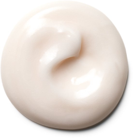 Een ronde stip lichtroze crème met een subtiele textuur, geïsoleerd op een witte achtergrond.