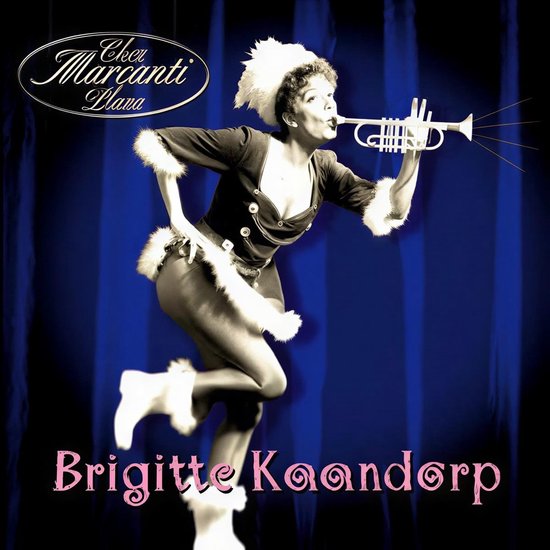 Brigitte Kaandorp in een kerstkostuum met bont, blaast op een trompet voor de tekst 'Brigitte Kaandorp'