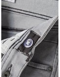 Grijze jeans met donker stiksel en een doorzichtige knoop voor verstelling.