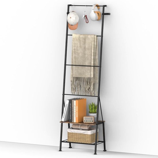 Zwarte handdoekladder met houten plank, mand, boeken en koptelefoon op de bovenste haak.