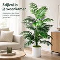 Stijlvolle groene kunstpalm in een witte pot, geplaatst in een modern woonkamerinterieur.