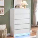 Witte commode met 5 lades, met een lamp en decoratie op de bovenkant, LED-verlichting onderaan.