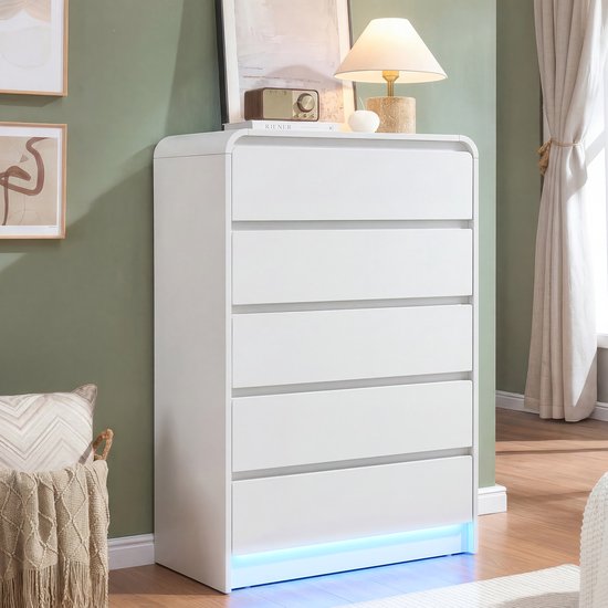 Witte commode met 5 lades, met een lamp en decoratie op de bovenkant, LED-verlichting onderaan.
