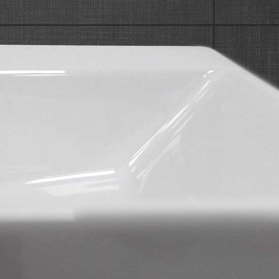Plan rapproché de la courbe brillante en céramique blanche d'un lavabo.