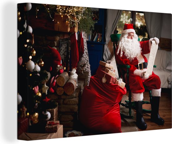 Canvas Schilderij De kerstman zittend in een stoel met zak vol geschenken - 60x40 cm - Wanddecoratie