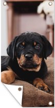 Tuinposter Rottweiler pup ligt op een zacht kussen - 30x60 cm - Tuindoek - Buitenposter