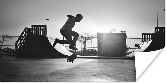 Poster Een jongen doet een stunt met zijn skateboard tijdens de zonsondergang - zwart wit - 40x20 cm