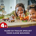 Mère et fille construisent l'ensemble de remorque à chevaux LEGO Friends, sur une table en bois.