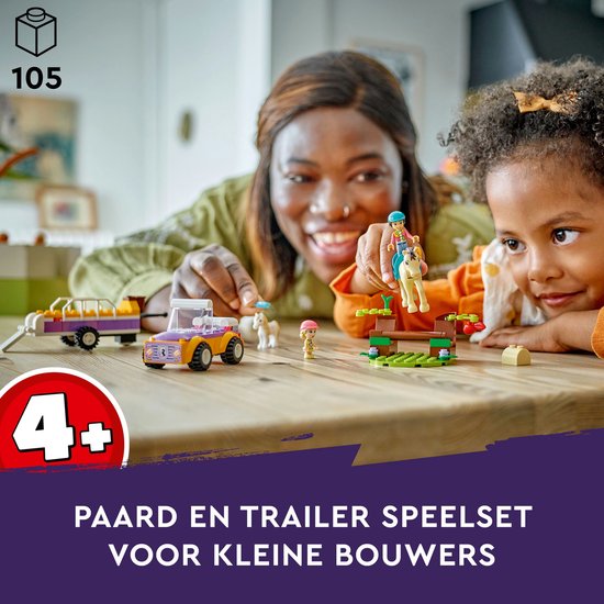 Mère et fille construisent l'ensemble de remorque à chevaux LEGO Friends, sur une table en bois.