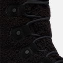 Detail van de vetersluiting en zwarte drukknoppen op de teddy-achtige schacht van een Sorel snowboot.