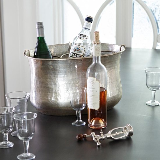 Grote, antiek zilverkleurige champagnekoeler met hamerdragend oppervlak, met drie flessen erin.
