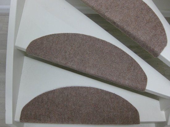 Beige halvemaanvormige trapmatten op witte treden.