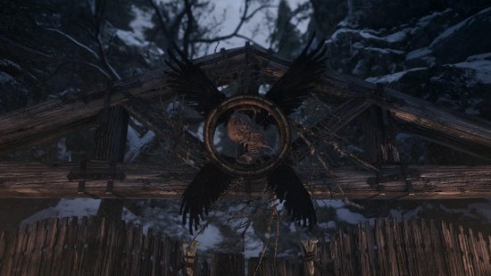Een houten poort met een symbool van een uil omringd door zwarte vleugels en takken.