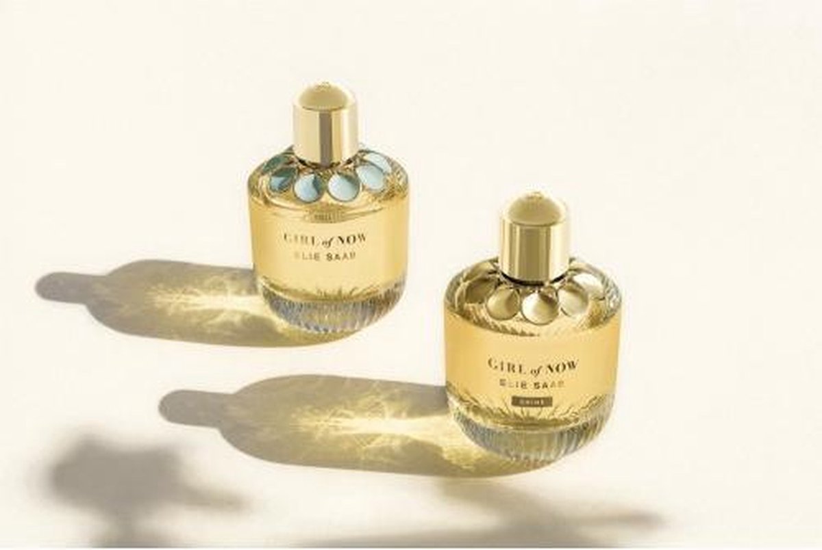 Doosje Elie Saab Girl of Now Shine Eau de parfum met gouden bloemen op blauwe achtergrond