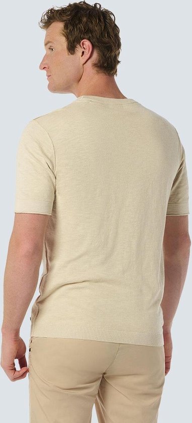 Dos d'un homme portant un haut beige à manches courtes.