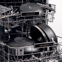 Zwarte KitchenAid pannen in een vaatwasser, met deksels en antislip bodem.