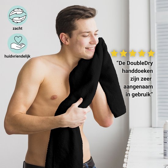Een lachende man dept zijn gezicht droog met een zachte, zwarte handdoek. Text: 'DoubleDry handdoeken zijn zeer aangenaam in gebruik'.
