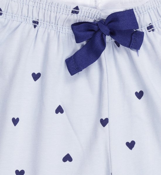Detail van de broek van een lichtblauwe pyjama, met donkerblauwe hartjesprint en een donkerblauw strikje op de tailleband.