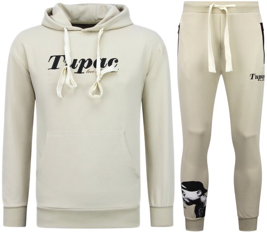 Beige trainingspak met hoodie en joggingbroek. Hoodie met tekst "Tupac love of the land". Joggingbroek met grafische print van Tupac op de broekspijp.
