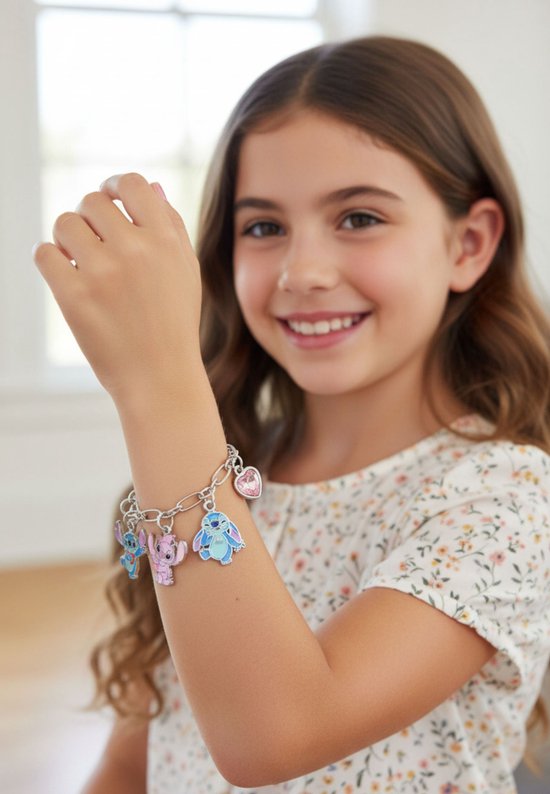 Arm van een jong meisje met een zilverkleurige schakelarmband met roze hartjes en Stitch en Angel bedeltjes.