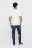 Achterkant van een man in een wit T-shirt en donkerblauwe skinny jeans.