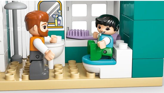 Homme et garçon Duplo près de toilettes et d'un lavabo avec miroir.