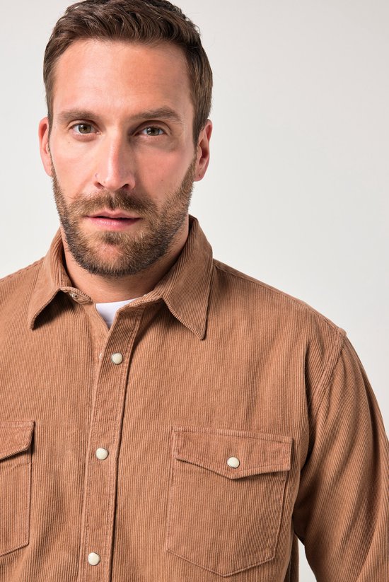 Close-up van model in een bruin corduroy overhemd met kentkraag, borstzakken en knoopsluiting.