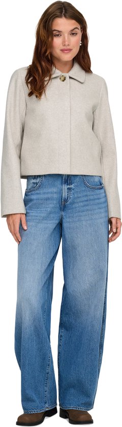 Model draagt een lichtgrijze korte jas van ONLY met jeans.