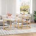 Set van 2 salontafels, een ovale en een ronde, met marmerlook blad en gouden frame, naast een bank.
