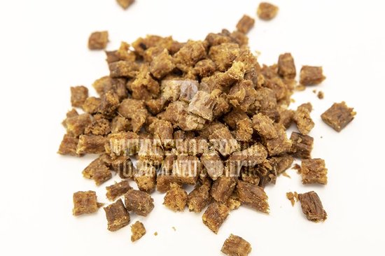 Een hoopje kleine, vierkante, bruine paardensnacks met een vlezige textuur.