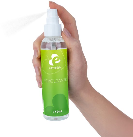 Main tenant et vaporisant une bouteille EasyGlide Toycleaner 150 ml. La bouteille a une étiquette verte.