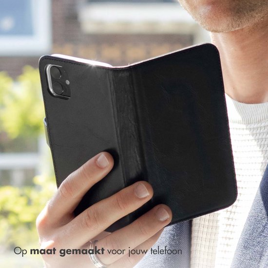 Man houdt zwarte lederen book case open, op maat gemaakt voor telefoon.