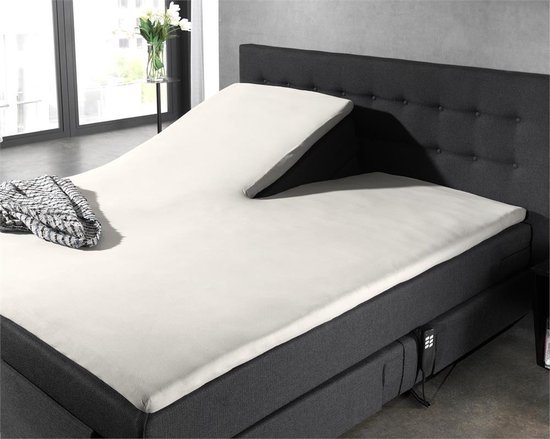 Verstelbaar bed met crème splittopper hoeslaken, donkergrijs hoofdbord en bedombouw, met deken.