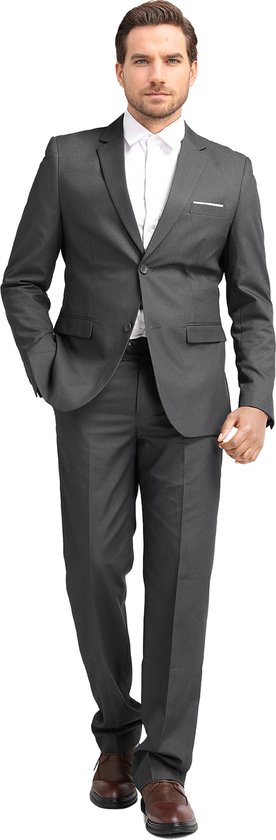 Man in donkergrijs slim fit pak met wit overhemd, staand, met hand in broekzak.