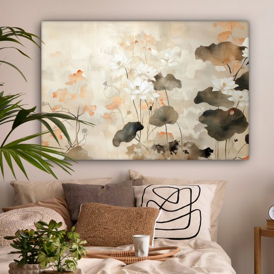 Slaapkamer met een canvasprint van witte lotusbloemen en bruine bladeren op een beige achtergrond, boven een bed met sierkussens.