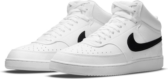 Paar witte Nike mid-top sneakers met zwarte swoosh en veters, van de zijkant bekeken.
