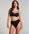 Model in een zwarte strapless beugel-bh met bijpassende high-waisted slip.