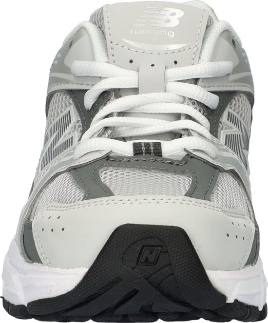 Vooraanzicht van een grijze New Balance sneaker met witte veters en een zwart accent op de neus.