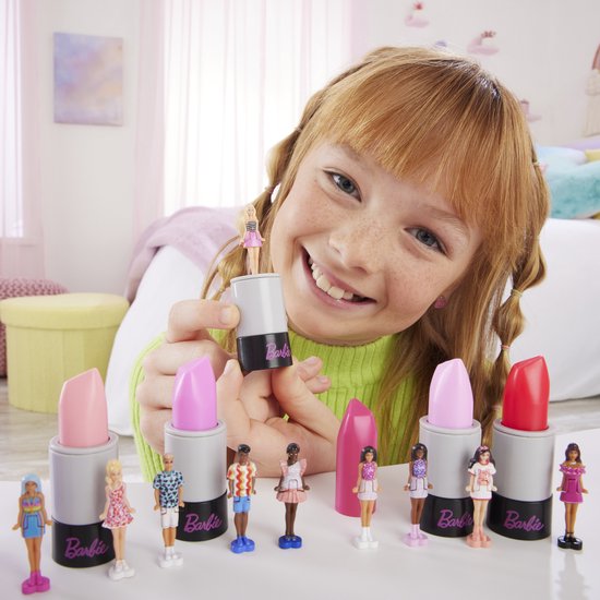 Meisje houdt Mini Barbie Land lipstick omhoog, omringd door diverse Mini Barbie poppen.