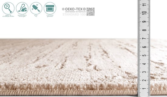 Détail de la hauteur du velours d'un tapis beige, marqué par une règle.