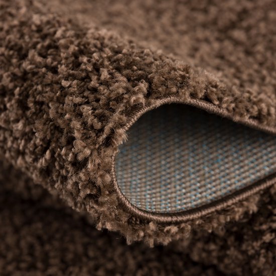 Detailopname van de zachte, bruine pool van een shaggy vloerkleed.