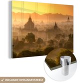 MuchoWow® Glasschilderij 150x100 cm - Schilderij acrylglas - Zonsondergang achter de bergen bij Bagan in Myanmar - Foto op glas - Schilderijen