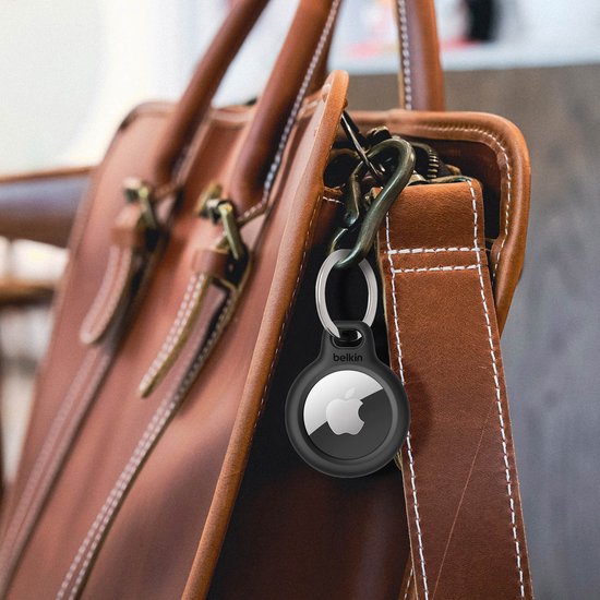 Zwarte Belkin AirTag houder met sleutelhanger aan een bruine leren tas.