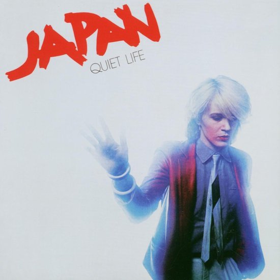 Albumhoes met Japan logo en titel "Quiet Life". Man met wit haar, blauwe blazer en gestreepte das.